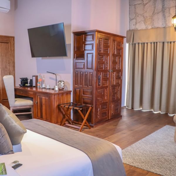Cupboard, desk & bed in the Deluxe Room at Gamma Hotels
