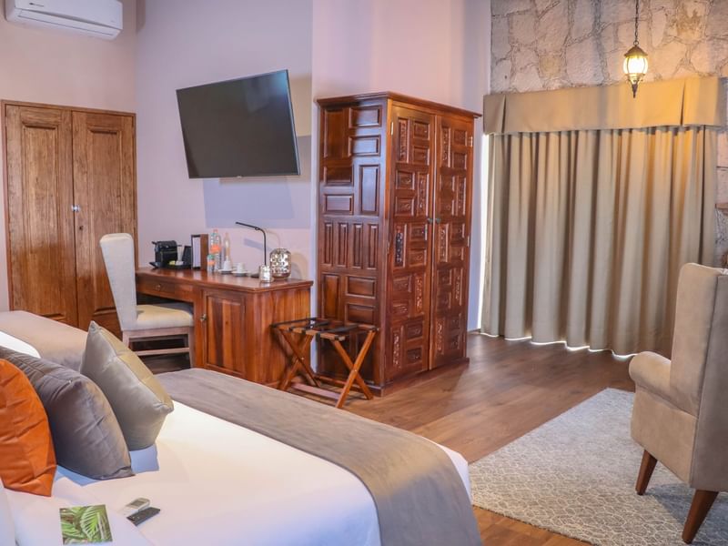 Cupboard, desk & bed in the Deluxe Room at Gamma Hotels