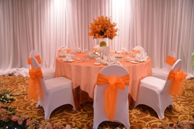A banquet table adorned with an orange sash at Eastin Grand Hotel Saigon