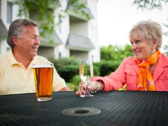 An Old Couple having drinks outdoors at Evergreen Resort