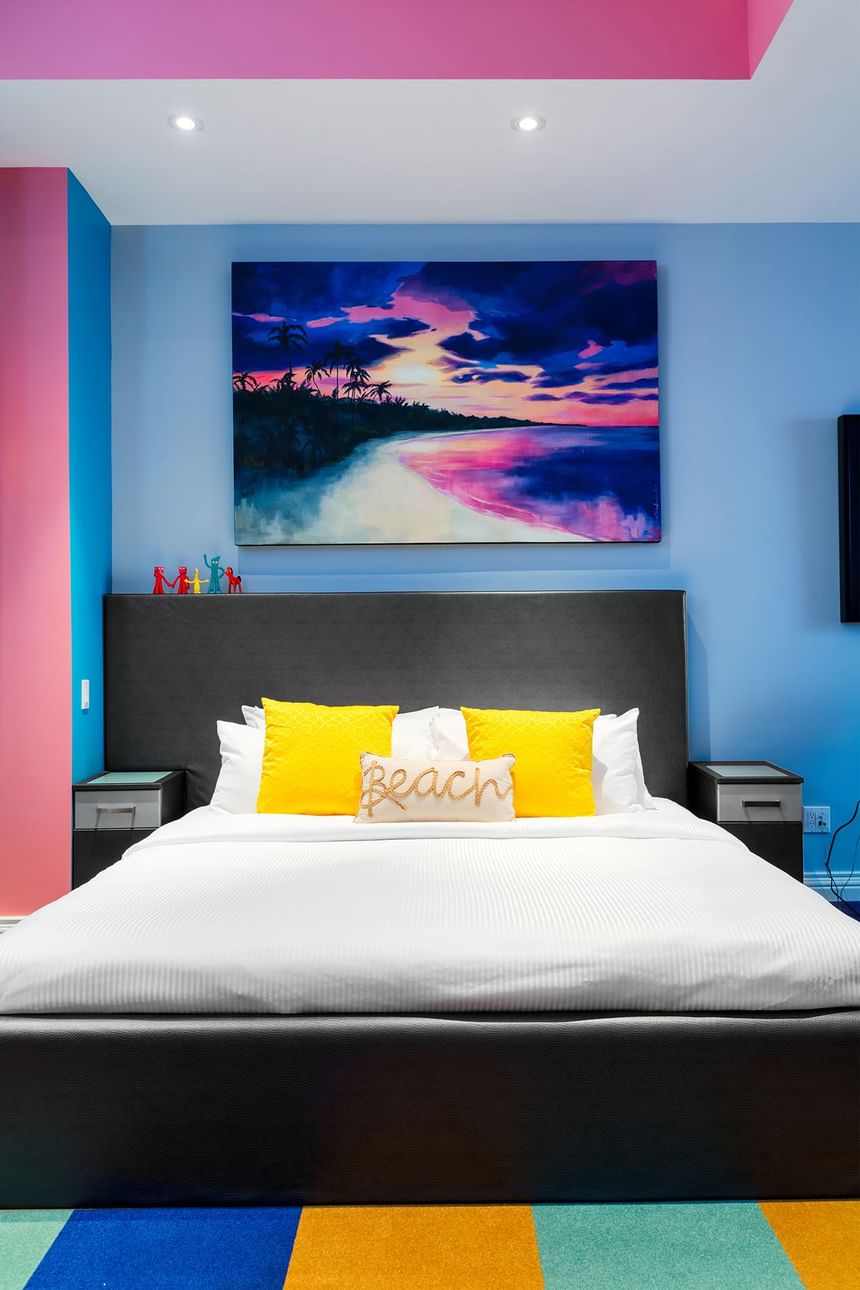 king bed with accent pillow that says beach with sunset artwork 