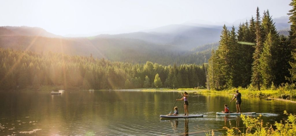People paddleboarding on Lost Lake in Whistler at sunset