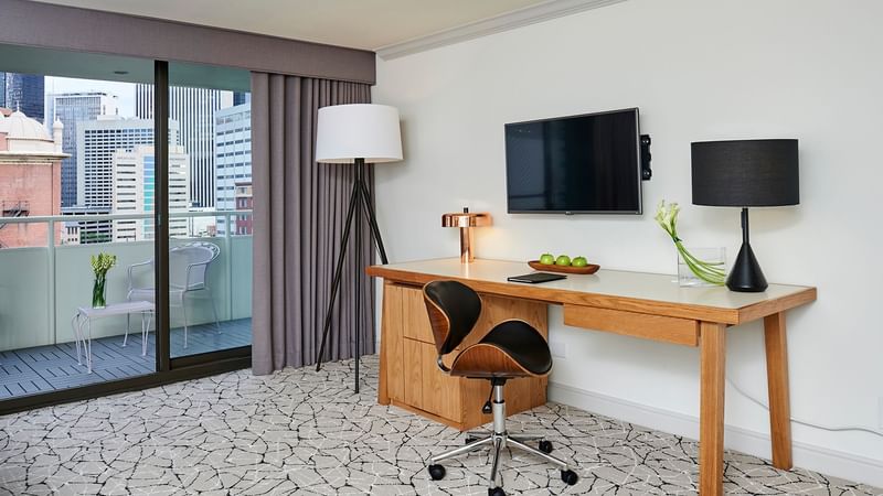 TV with working table and balcony in Deluxe Room at Warwick Denver