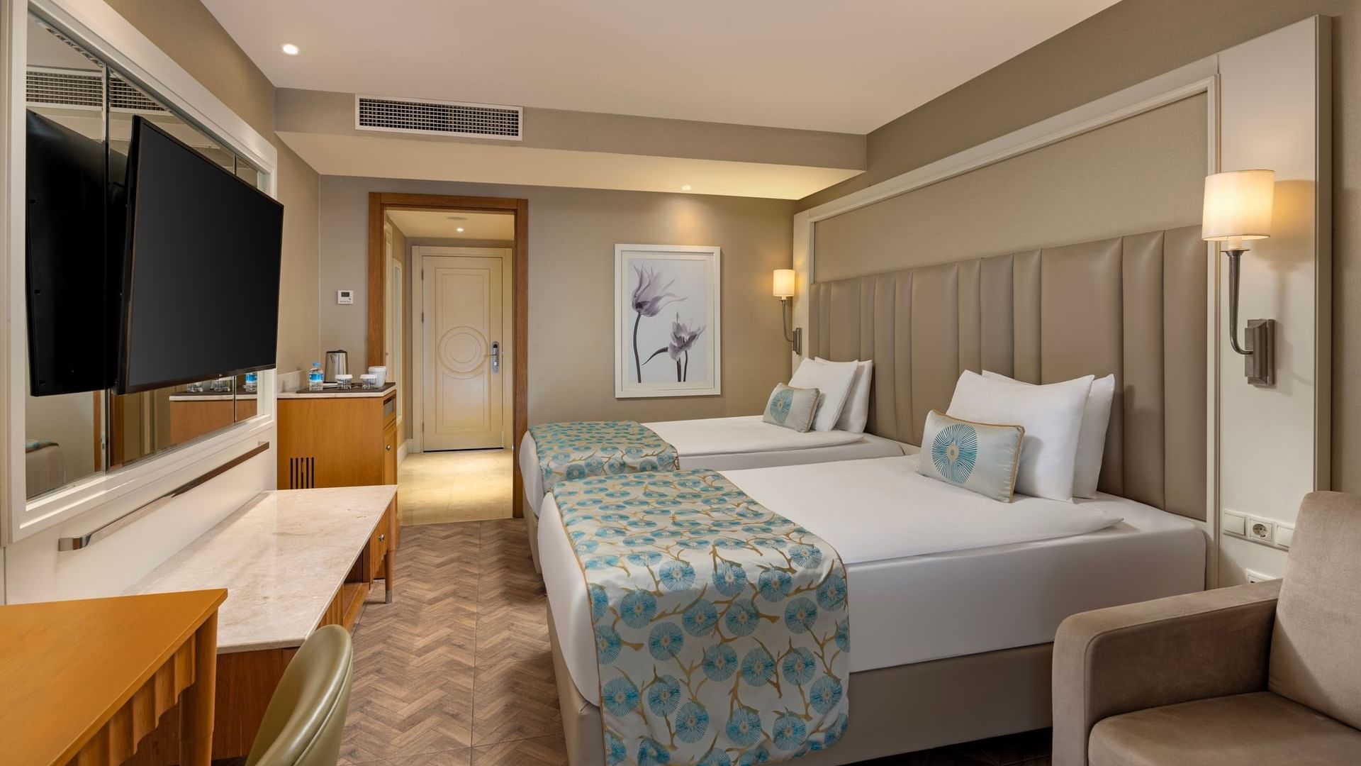 A stylish hotel room with two beds, a desk, and a television at Titanic Deluxe Lara.