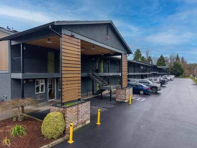Exterior view of The Varsity North with a clean parking lot under a partly cloudy sky, one of the top hotels in Centralia, WA
