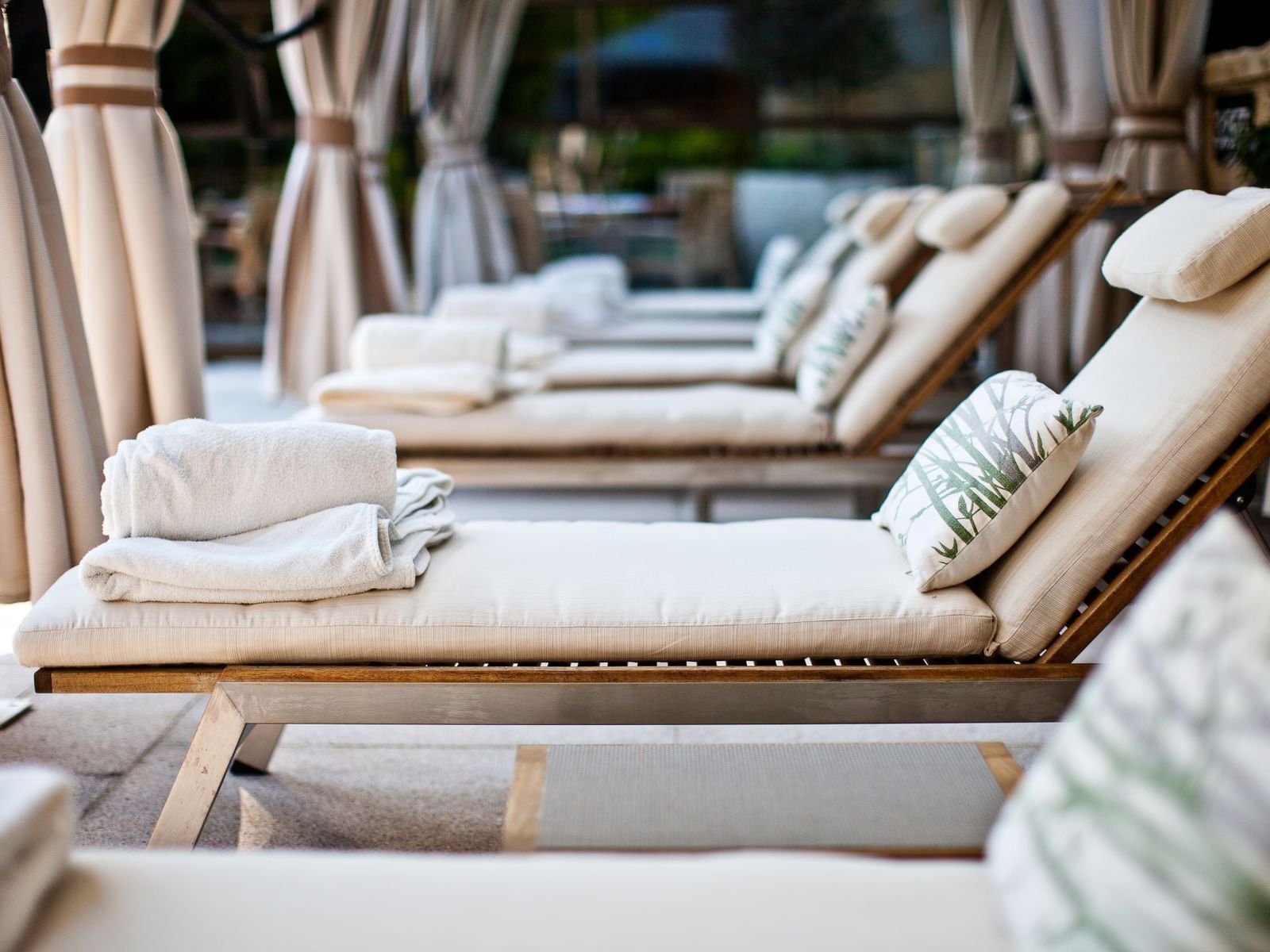 Close-up of lounge chairs featuring towels & pillows at The Umstead Hotel and Spa