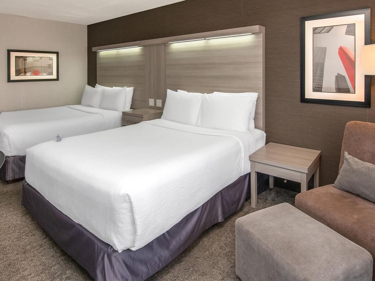 Coast Premium Two Queens room with two queen beds, modern headboards, and seating area at Coast Calgary University Area Hotel by APA