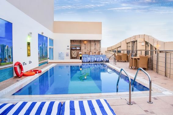 Rooftop pool area with sun loungers at The Royal Riviera Hotel