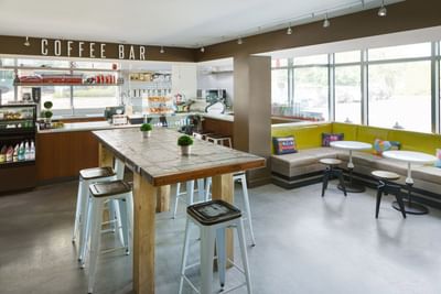 J House Coffee Bar with stools by a wooden table at The J House Greenwich, a modern boutique hotel in Greenwich Connecticut