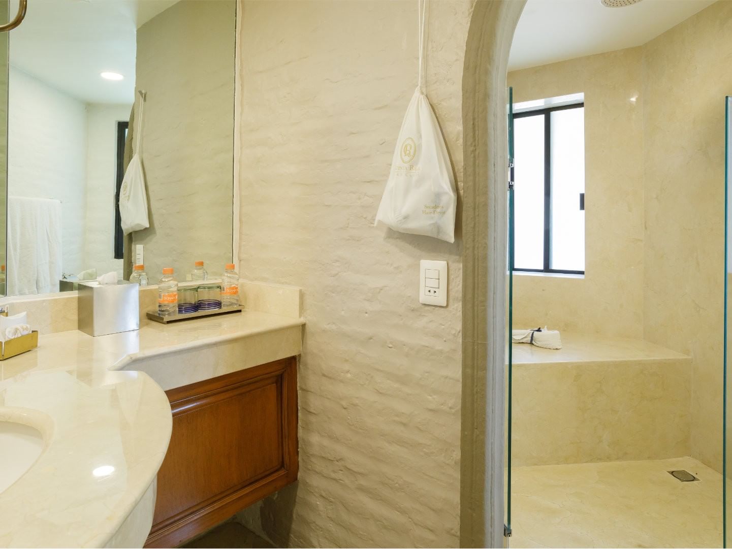 King Presidential Suite bathroom featuring a stone walk-in shower and cream marble vanity at Quinta Real Guadalajara