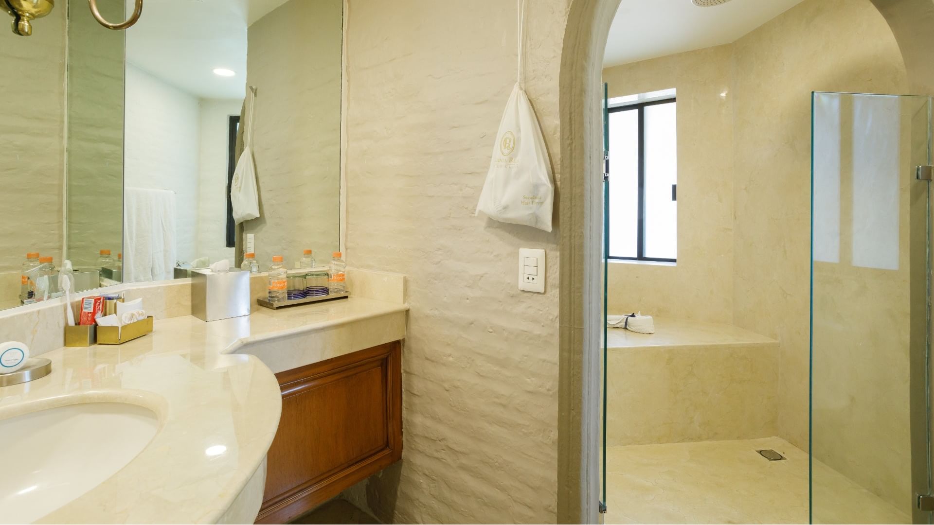 King Presidential Suite bathroom featuring a stone walk-in shower and cream marble vanity at Quinta Real Guadalajara