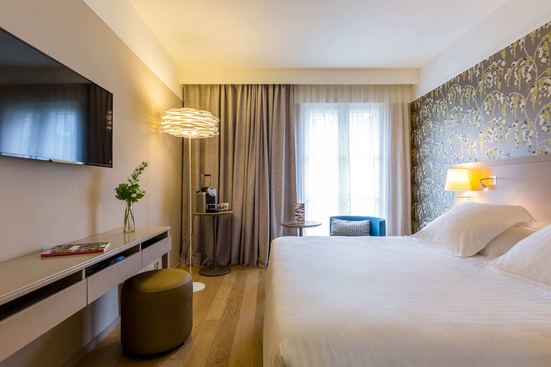 Lit king-size avec télévision dans une chambre à Oceania Hôtel de France Nantes