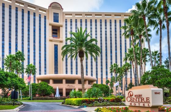 Rosen Centre Hotel facade with towering palm trees and landscaped main entrance beneath blue skies near Rosen Inn Hotels