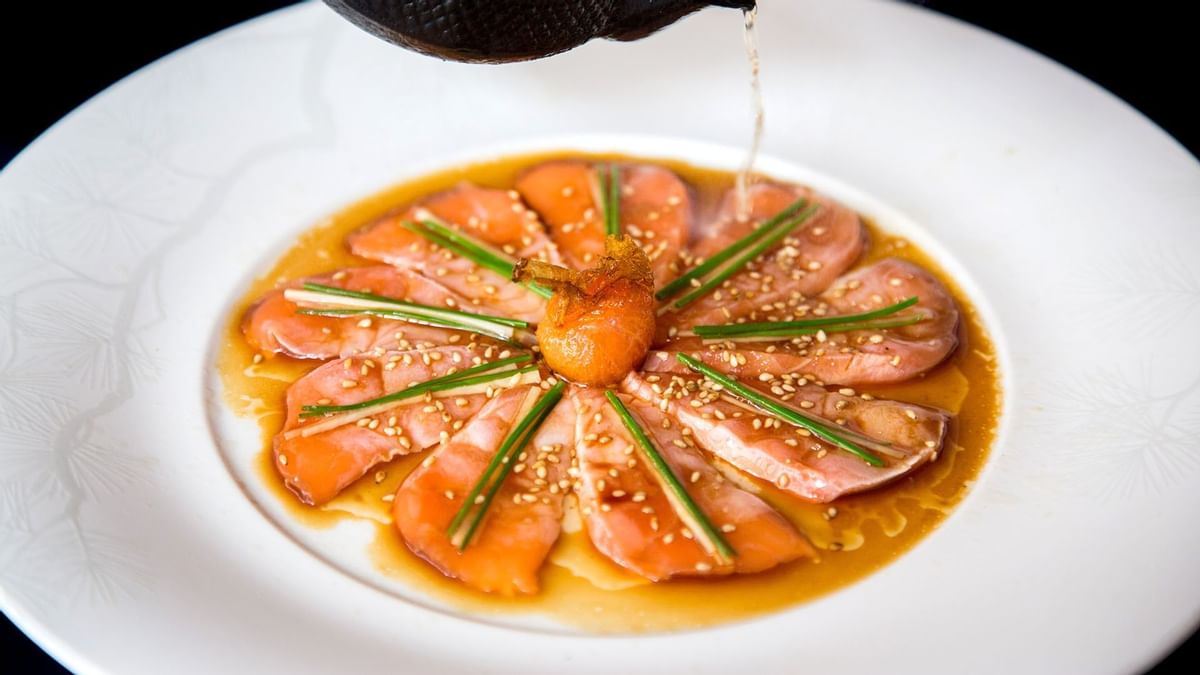Sliced salmon sashimi garnished with chives, and sesame seeds in Nobu at Crown Towers Sydney