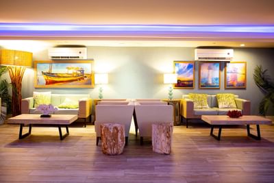 Relaxing lounge area featuring coastal artwork, soft lighting, and plush seating at Margaritaville Resort Biloxi