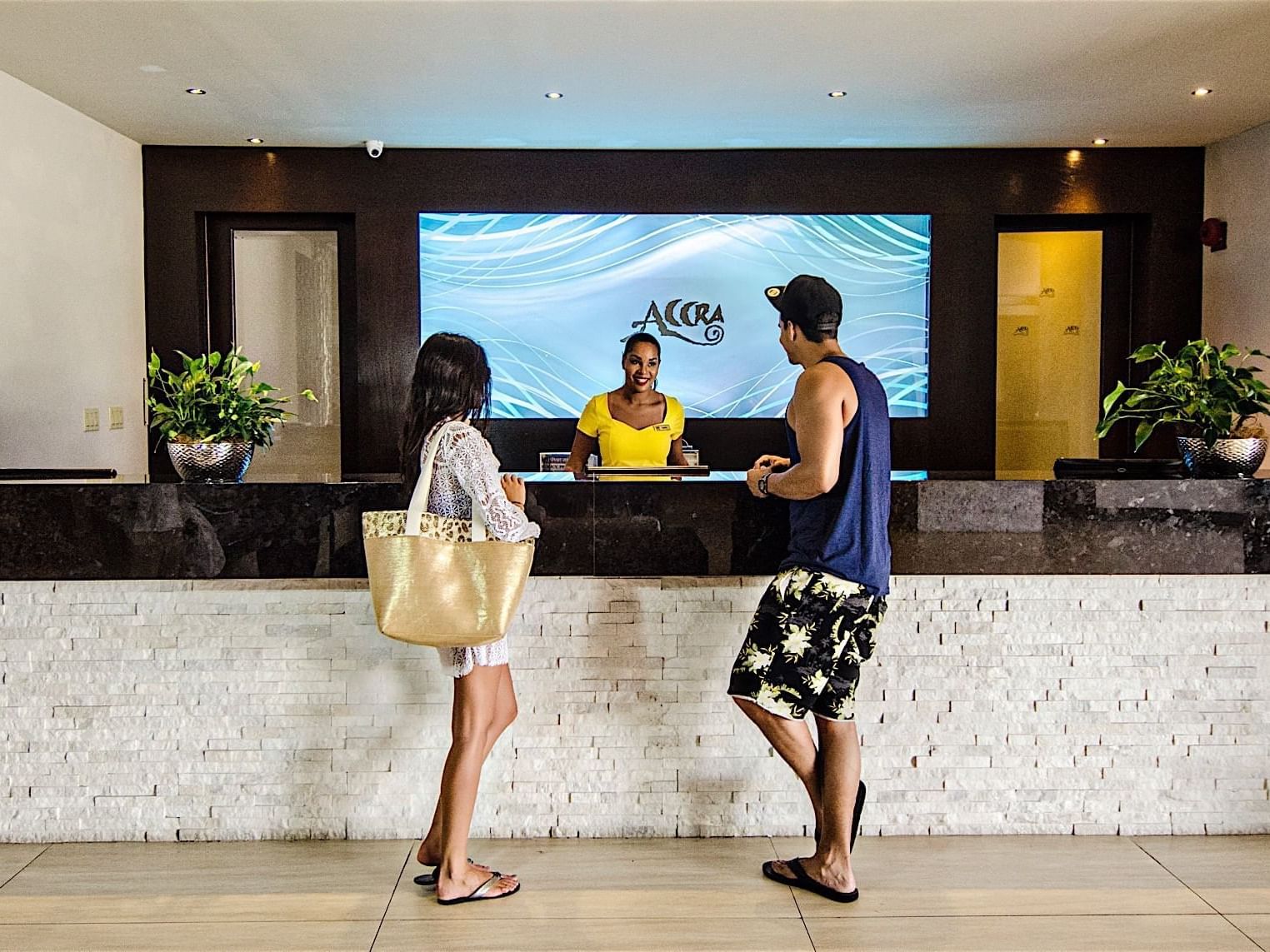 Couple talking to a receptionist by the front desk at Accra Hotels & Resorts