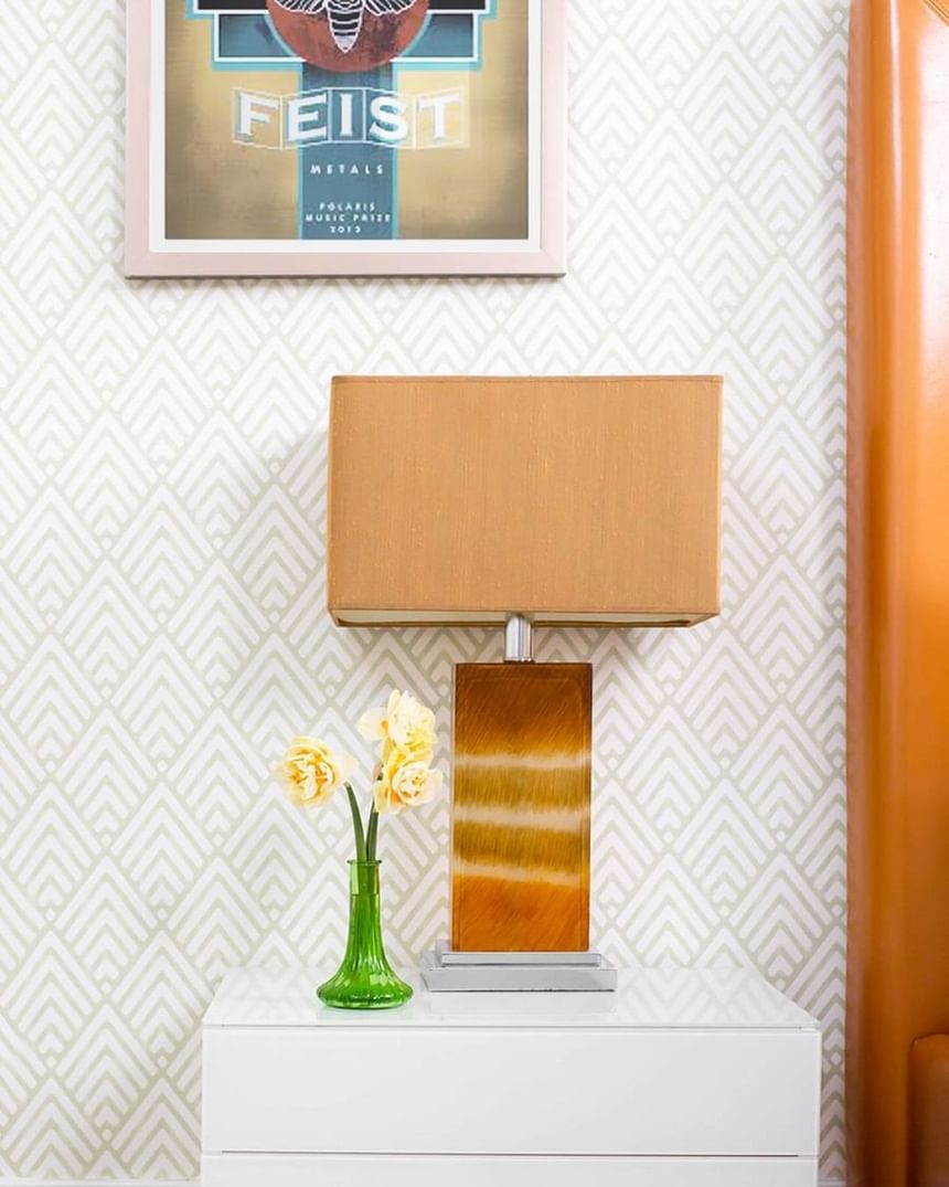 orange lamp on bedside table in spring fling with Feist poster