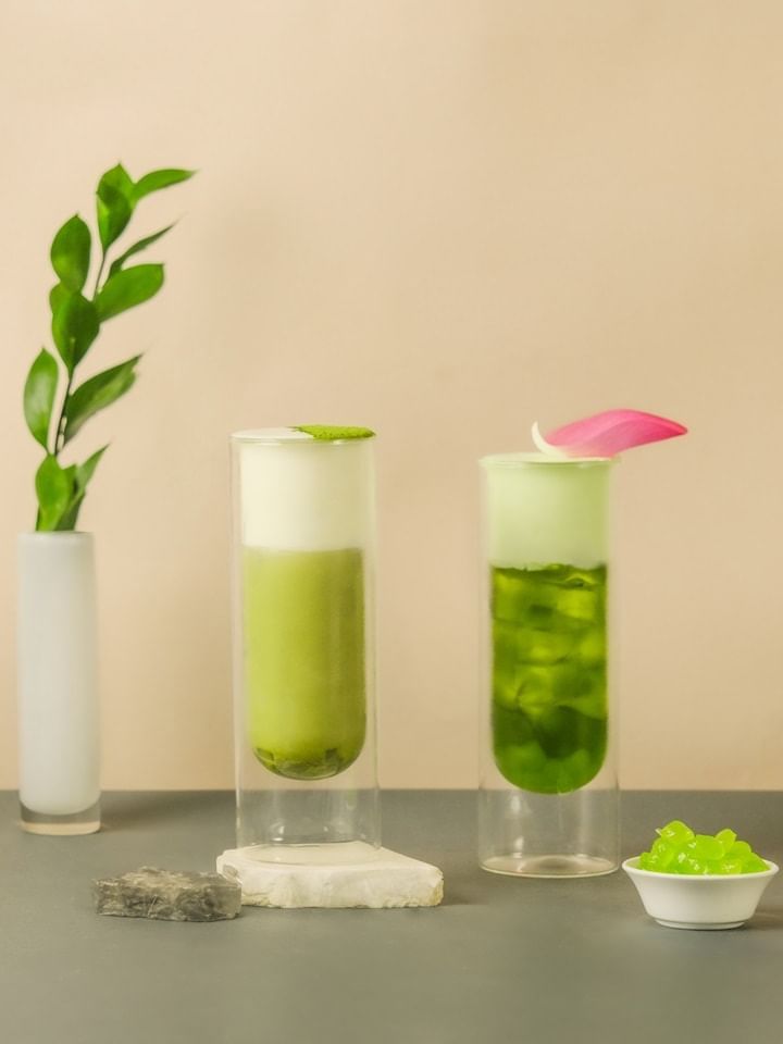 Two coconut matcha milk teas garnished with mint and a pink petal in Park Lounge at Park Hyatt Saigon