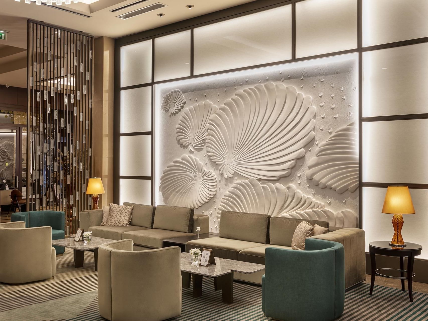 Titanic Business Kartal’ın otel lobisinde, rahat koltuklar ve masalar düzenli bir şekilde yerleştirilmiştir.