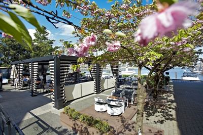 View of dockside patio on sunny day at Granville Island Hotel