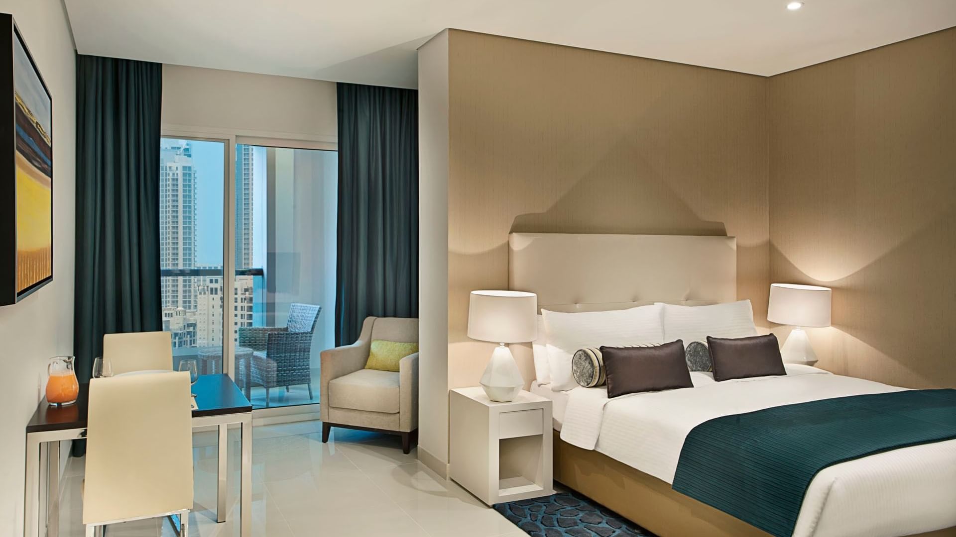 Modern furniture featuring a king bed & decor with a city view in the Deluxe Room at DAMAC Maison Cour Jardin