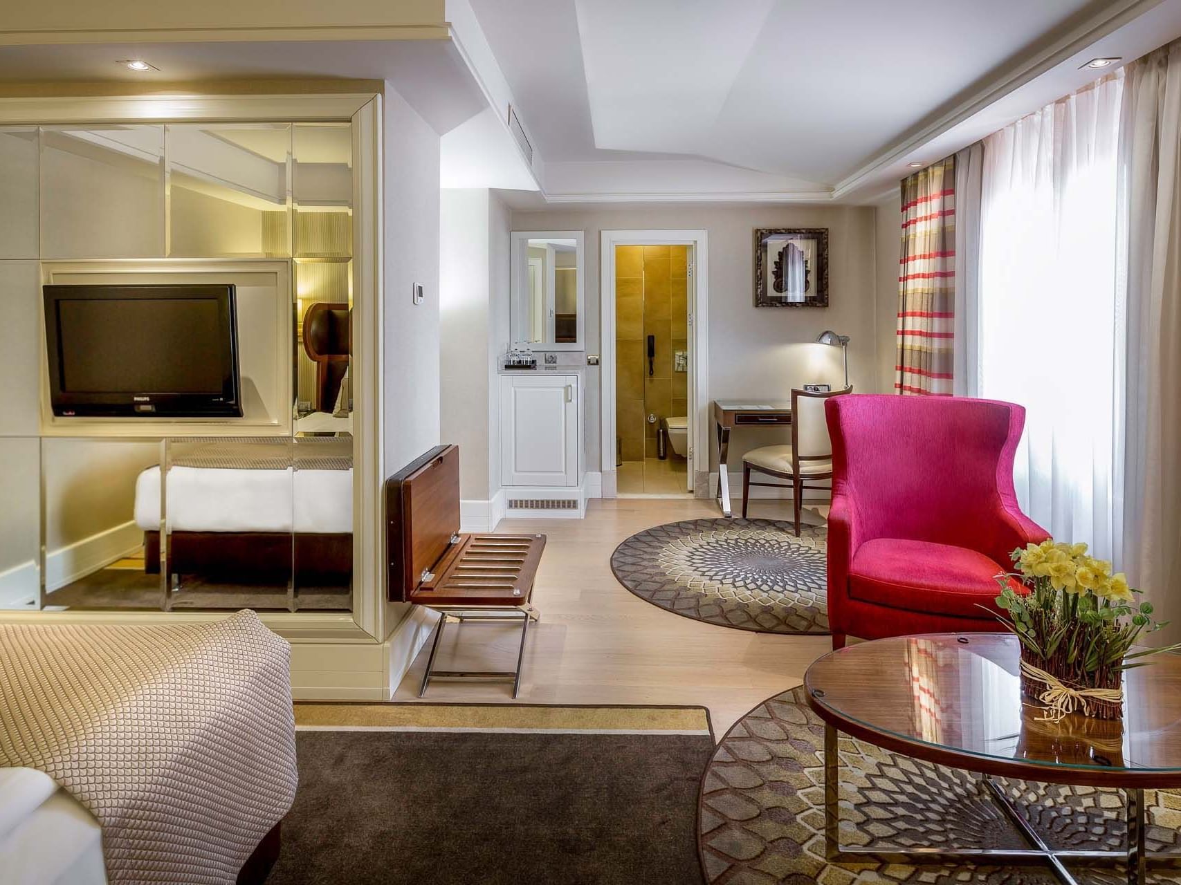 Superior Room with a chair and reflective TV wall partition at Titanic Comfort Sisli 