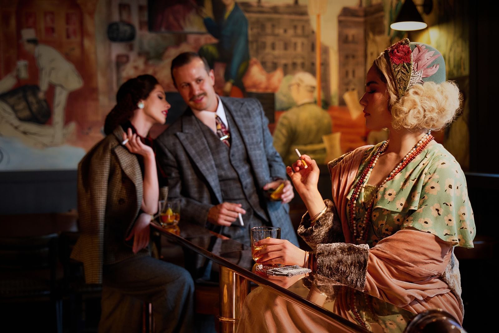 Stylish individuals enjoying drinks in a retro-themed Midnight Bell bar at The Londoner Hotel, capturing a vintage ambiance