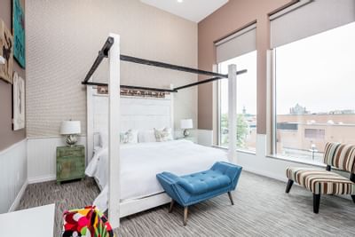 Canopy bed with window view & comfy chairs in Superior Loft Cottage at Retro Suites Hotel