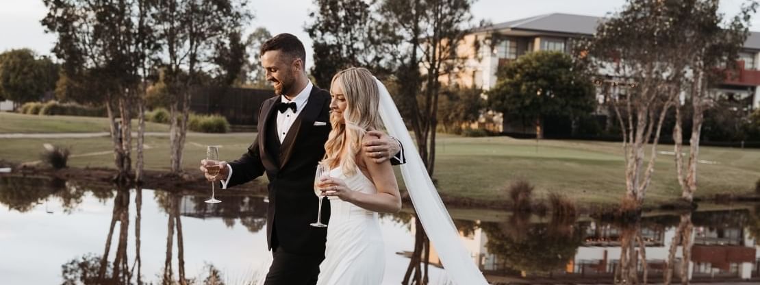 wedding couple walking across golf course