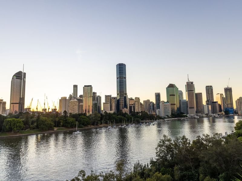 City skyline at sunset with waterfront and trees in Kangaroo Point near Sofitel Brisbane Central