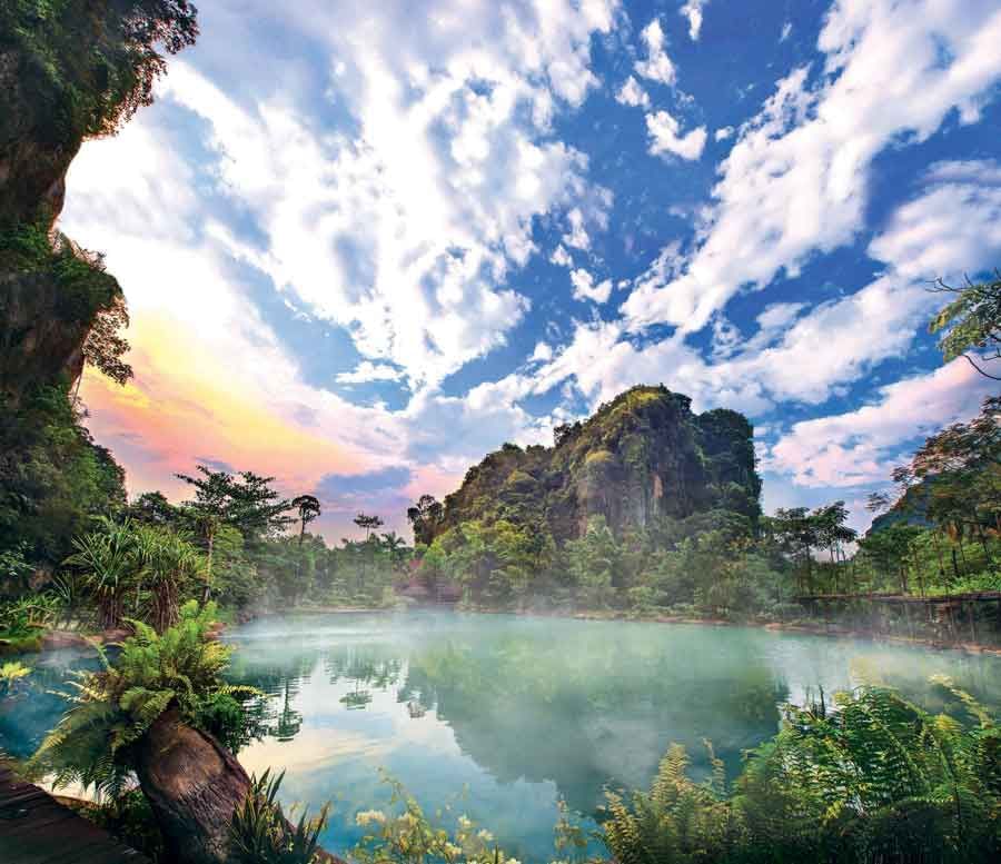 Misty hot springs with lush greenery and a sunset sky near Sunway Hotels & Resorts