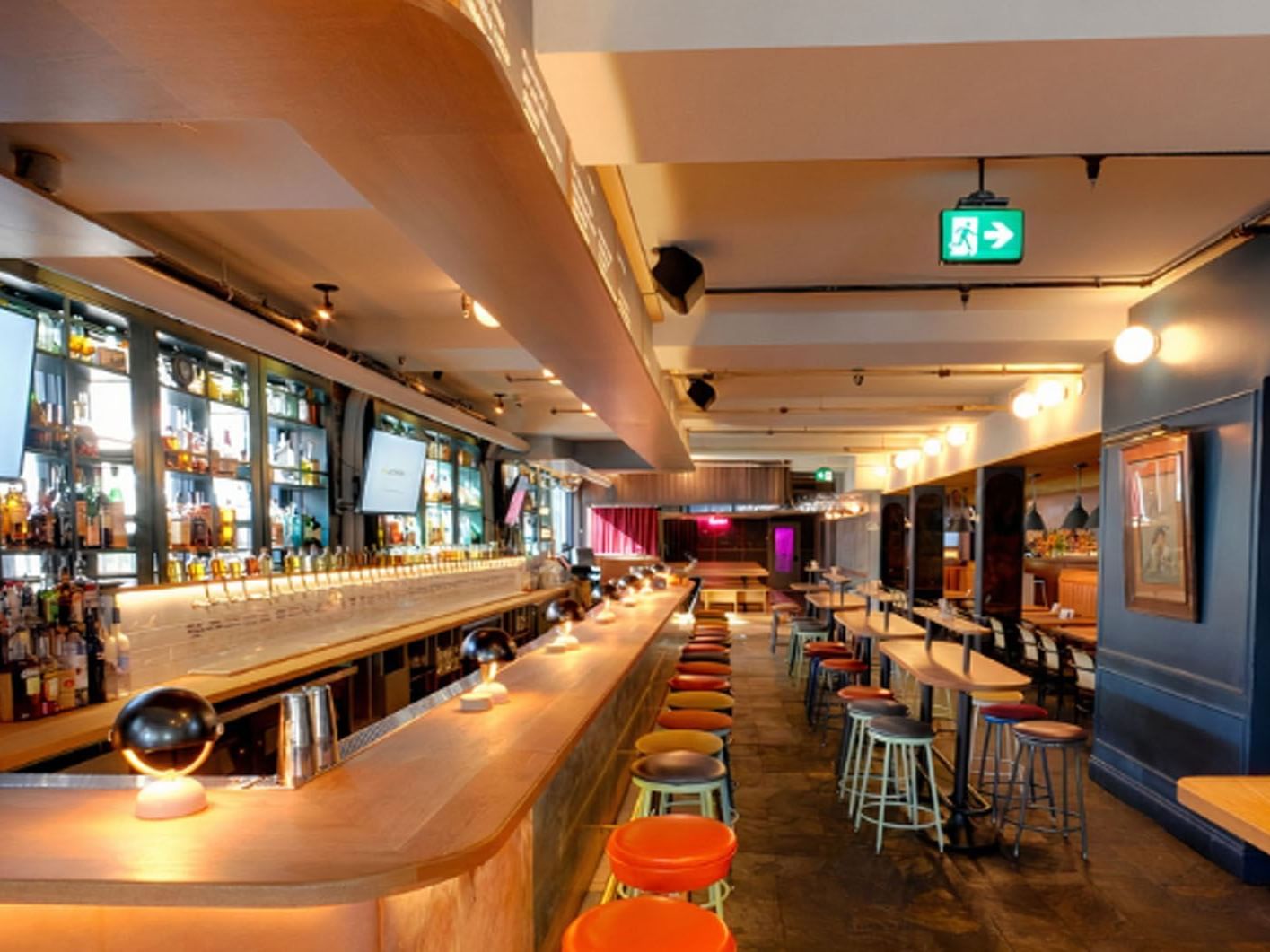 Belfast Love Public House with stools, a long bar counter, and assorted bottles near Hotel X Toronto