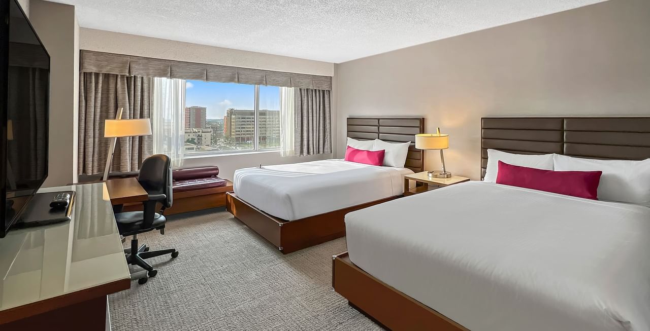 Hotel room with two queen beds, a TV, a desk and chair