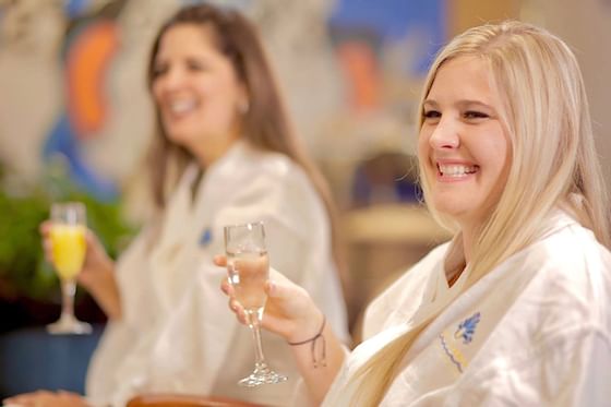 Friends in robes smiling with wine at Safety Harbor & Resort