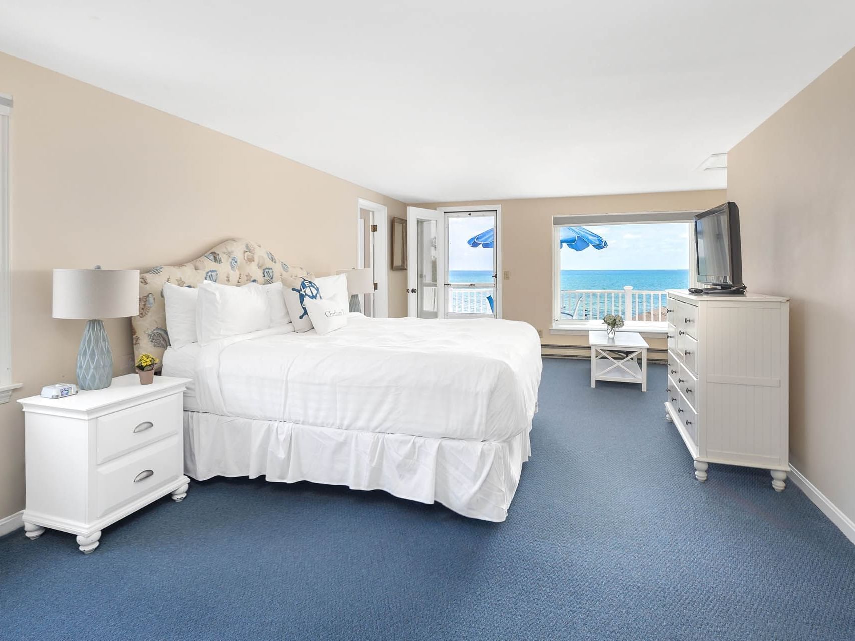 Double bed and nightstand with a TV in Hightide Oceanview Three Bedroom Suite at Chatham Tides Resort