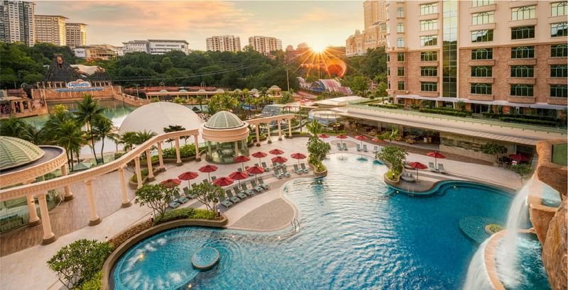 Aerial view of the outdoor pool complex and waterpark near Sunway resort, vibrant sunset in the background