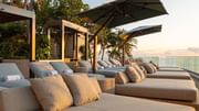 Cushioned daybeds at Verandah Social Club with an ocean view.