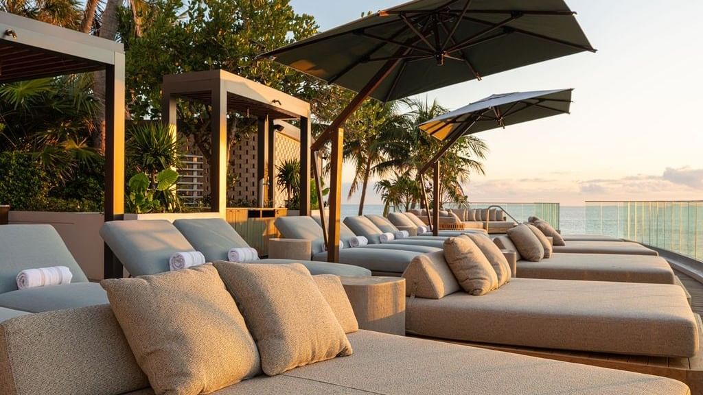Cushioned daybeds at Verandah Social Club with an ocean view.