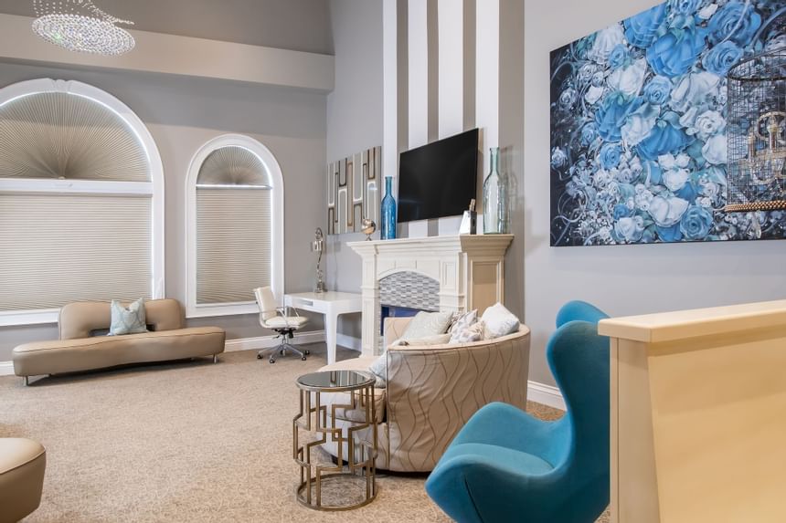 Living area with TV, comfy couch, fireplace & painting on the wall in Presidential suite at Retro Suites Hotel