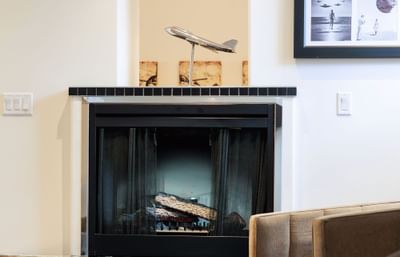 The first-class suite living area, complete with stylish couches and captivating airport and geographic art.