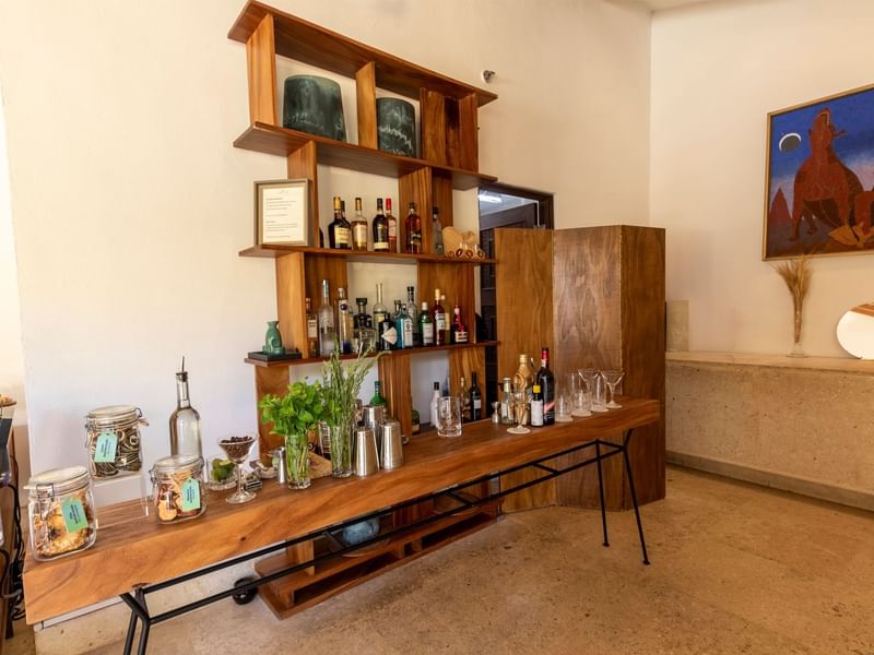 Wooden mini bar setup with shelves of bottles and glasses at Grand Fiesta Americana