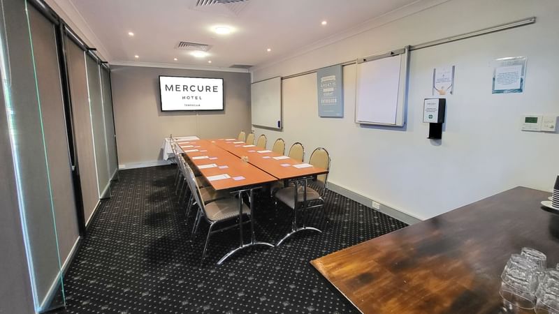 Boardrooms 1, 2 and 3 featuring a large table, chairs and presentation screen at Mercure Hotel Townsville