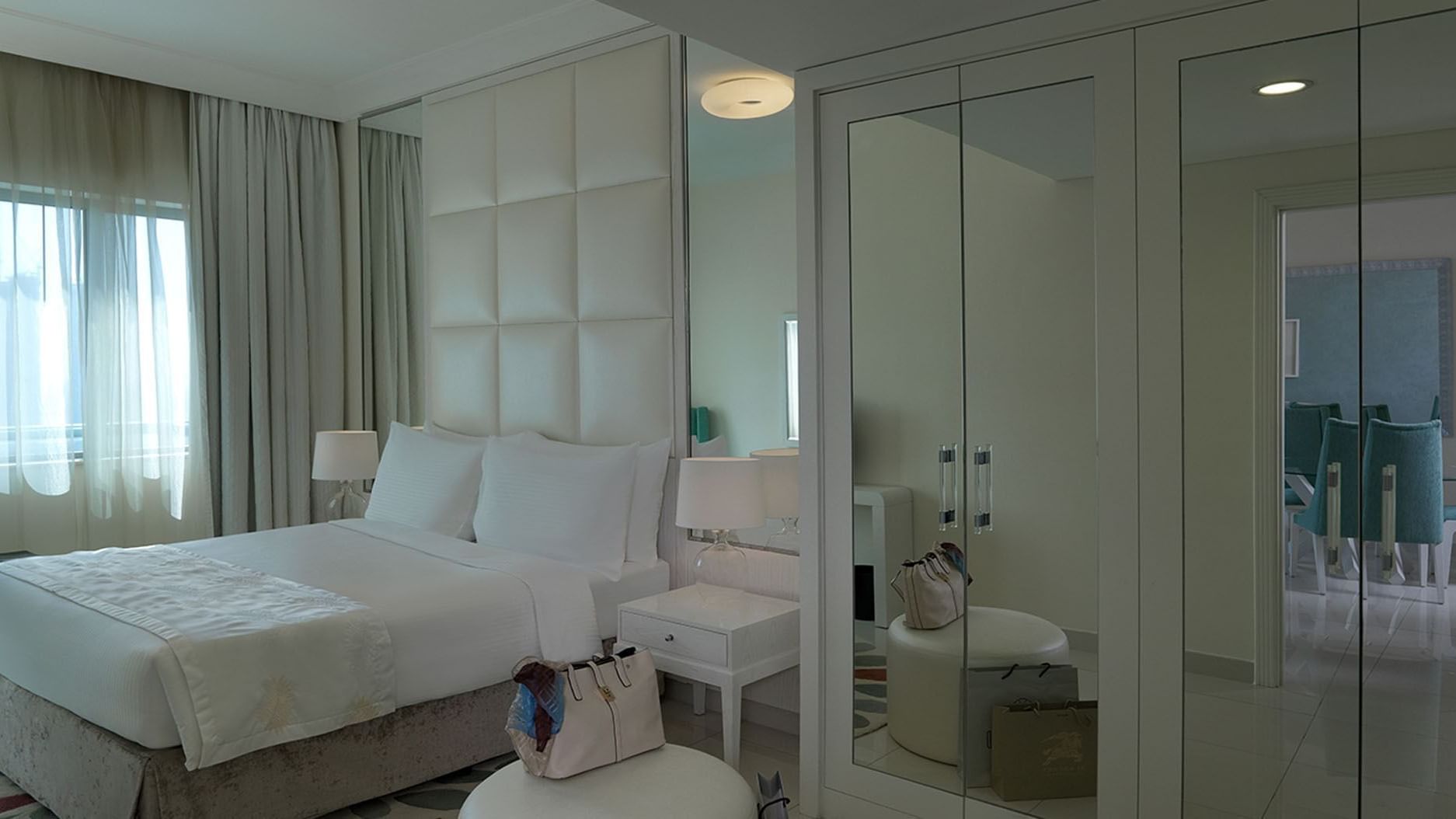 Cozy bed with side tables and wardrobe with two mirrors in a room at DAMAC Maison Dubai Mall Street