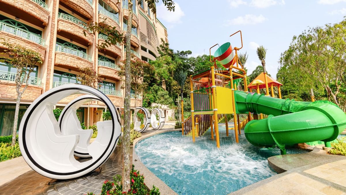 Water play zone featuring colorful slides, a tipping bucket, and cozy lounging pods at Sunway Resort