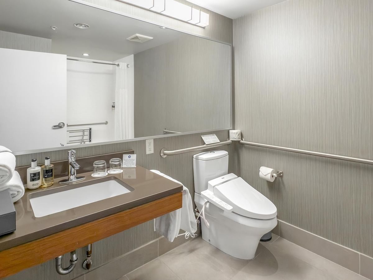 Accessible bathroom with toilet, sink, and grab bars.