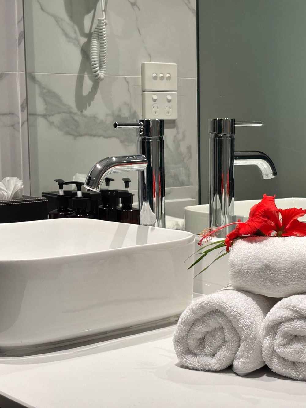 White sink with towels and flowers in bathroom of Superior Garden View Room at Warwick Fiji Resort and Spa, Korolevu.