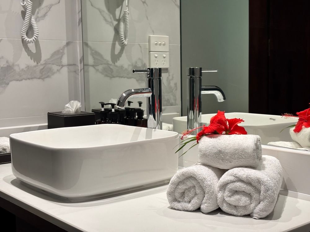 White sink with towels and flowers in bathroom of Superior Garden View Room at Warwick Fiji Resort and Spa, Korolevu.