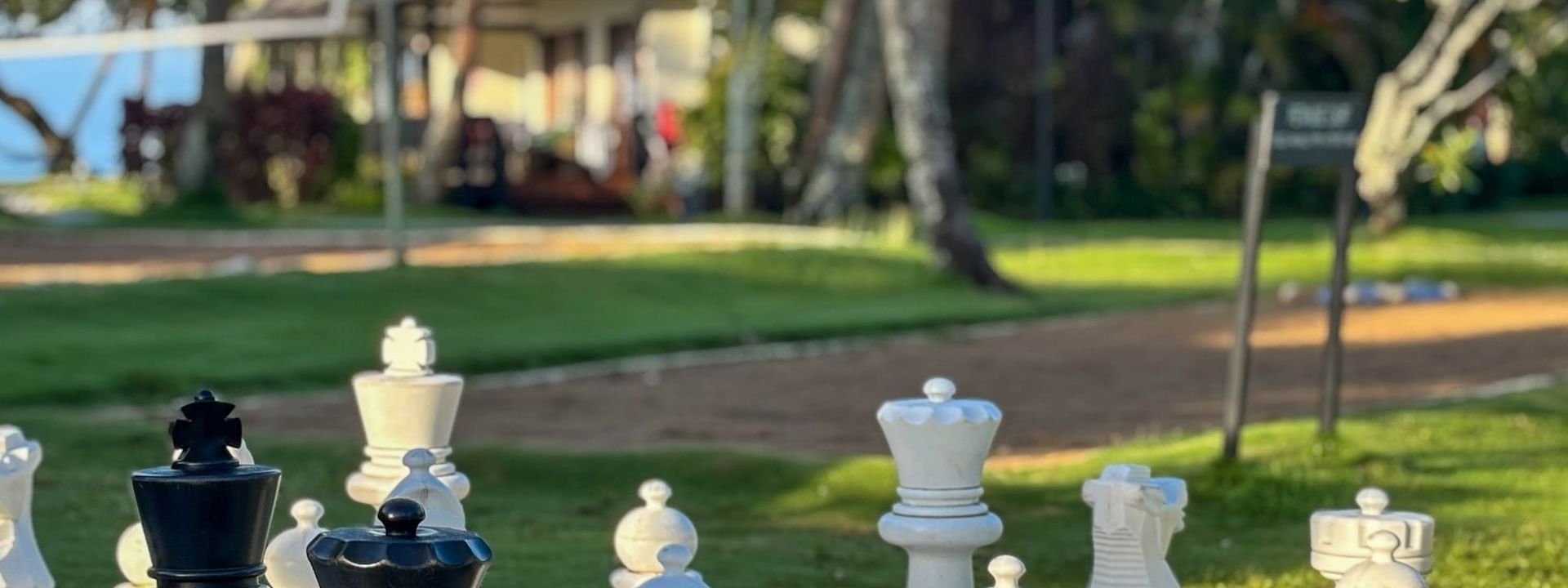 Large chess pieces by a sandy path under bright sunlight surrounding a garden at The Naviti Resort Korolevu Fiji