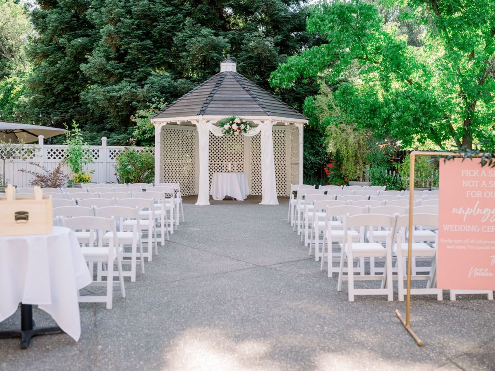 Outdoor wedding ceremony setup featuring rows of white chairs in the Gazebo at Lake Natoma Inn
