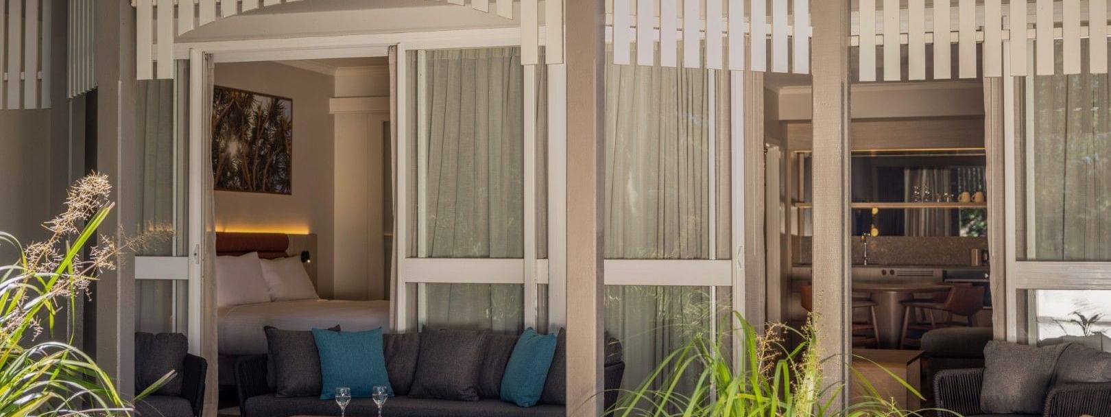 Private terrace with outdoor seating and tropical plants outside a Deluxe Two Bedroom at Novotel Sunshine Coast Twin Waters